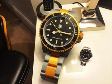 Ogromny zegarek z nadrukiem 3D obok zwykłego zegarka.