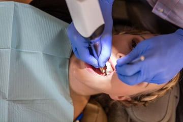 Dentysta skanujący usta pacjenta skanerem dentystycznym