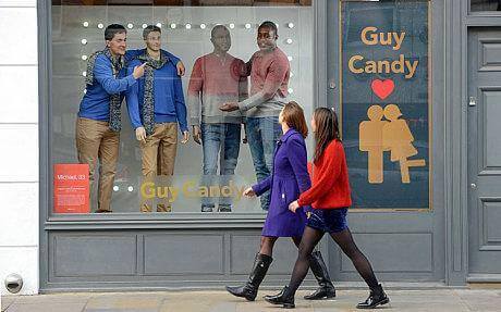 Two persons and their doppelgangers in the "Guy Candy" store window