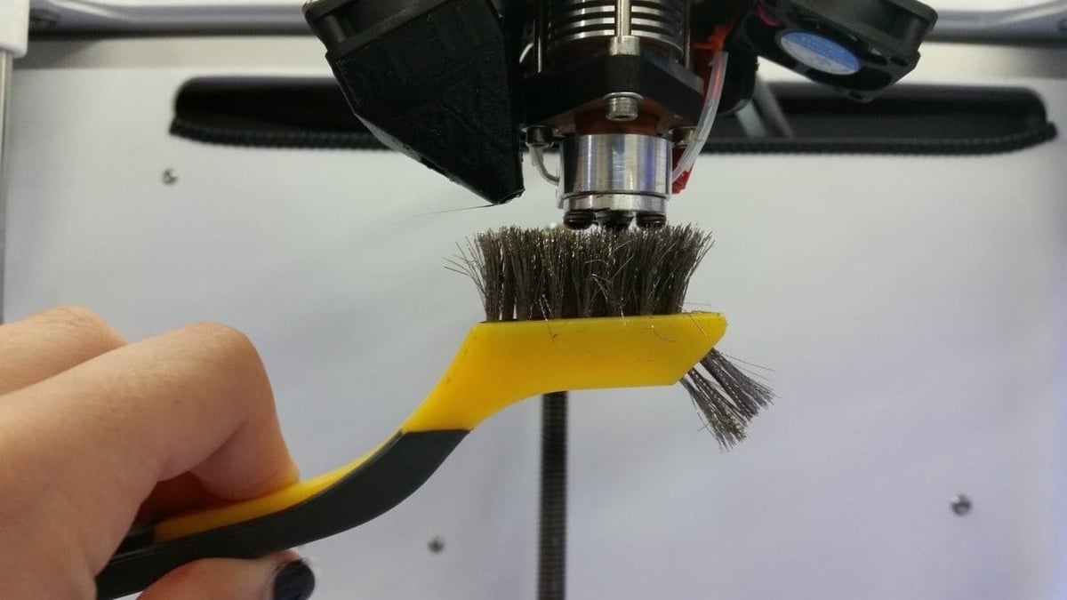 Cách làm sạch đầu phun máy in 3D bằng bàn chải.