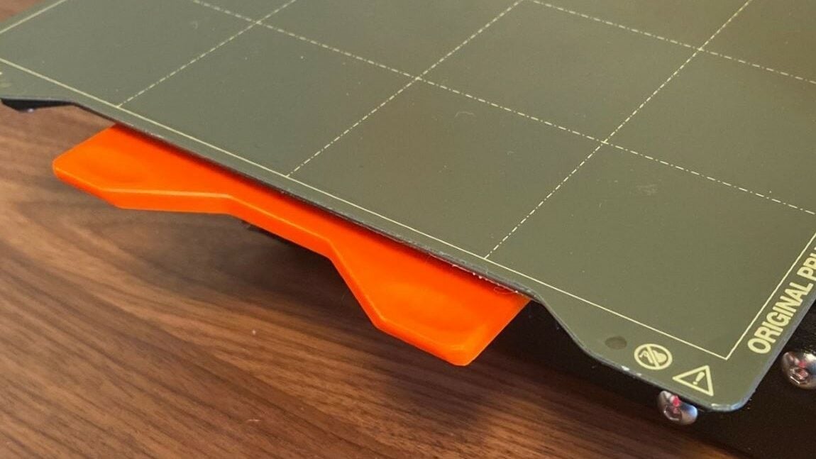 The heated bed thumb tabs provides leverage points for removing the build plate