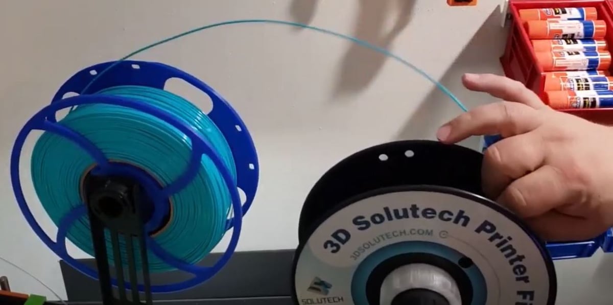 You can use a drill or just your hands to spin the filament from one spool to the other