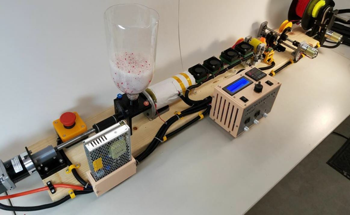 The RecycleBot is a fairly long machine, made up of many wood and 3D printed parts