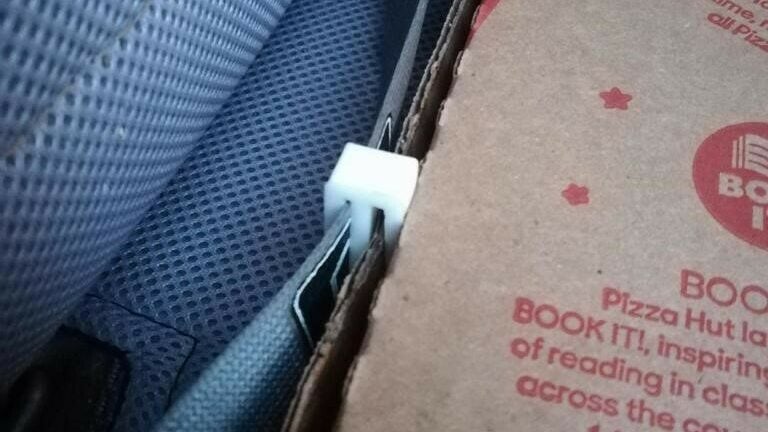 The pizza clip clips to the waist of the seatbelt.