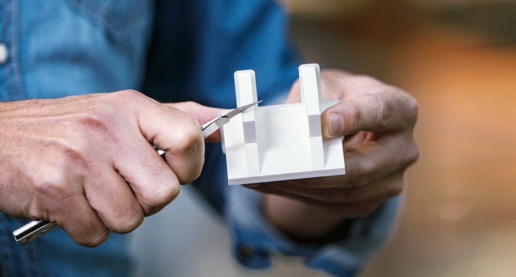 Cleaning up build material supports with an X-Acto knife.